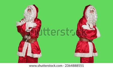 Santa claus character winter celebration on greenscreen backdrop, positive confident person in traditional festive costume with hat and beard. Young man spreading holiday spirit.