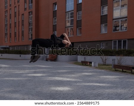 Man taking photos while doing somersault outdoors.  Royalty-Free Stock Photo #2364889175