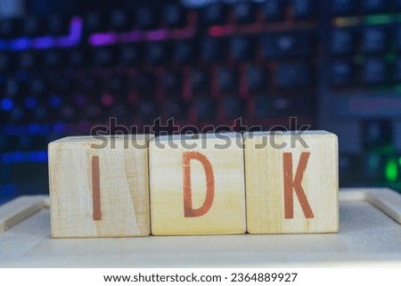 Photo of words with wooden block objects arranged into the word "IDK" in English