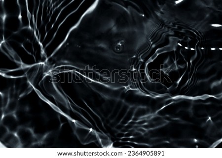 Black water with ripples on the surface. Defocus blurred transparent blue colored clear calm water surface texture with splashes and bubbles. Water waves with shining pattern texture background. Royalty-Free Stock Photo #2364905891