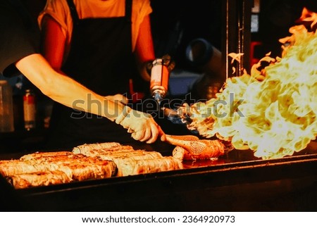 Delicious grilled pork cooking on fire, street food in Jeju island. Royalty-Free Stock Photo #2364920973