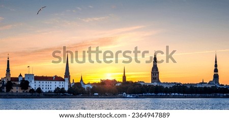 Panoramic image with sunrise above historical district of Riga - the capital city of Latvia, it offers for tourists many resting opportunities and unique medieval and Gothic architecture
