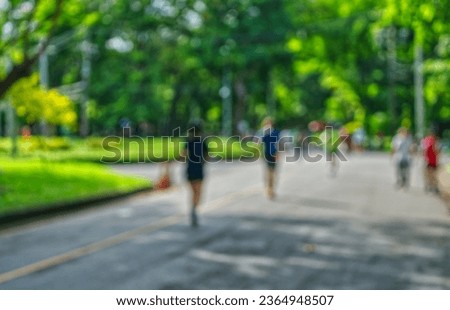 Blurred image of people jogging in the park of Bangkok, Thailand in the morning, landscape image activity in a public park.