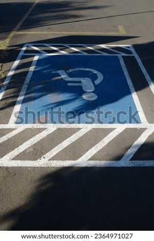 signs on the asphalt of the disabled parking area