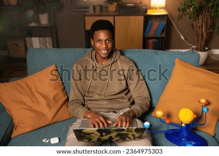 Dark skinned black man guy student responding to a message or comment from someone on social media, indicating his agreement or appreciation for content offering encouragement or support to someone. Royalty-Free Stock Photo #2364975303