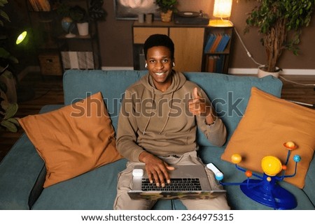 Happy delighted african american dark skinned black man responding to a message comment from followers friends family on social media, indicating his agreement or appreciation for the content. Royalty-Free Stock Photo #2364975315