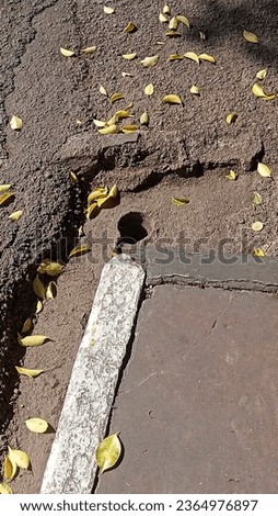 hole beside the sidewalk at 11 am