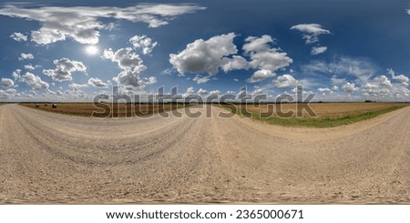 360 hdri panorama on gravel road with marks from car or tractor tires with clouds on blue sky in equirectangular spherical  seamless projection, skydome replacement in drone panoramas Royalty-Free Stock Photo #2365000671