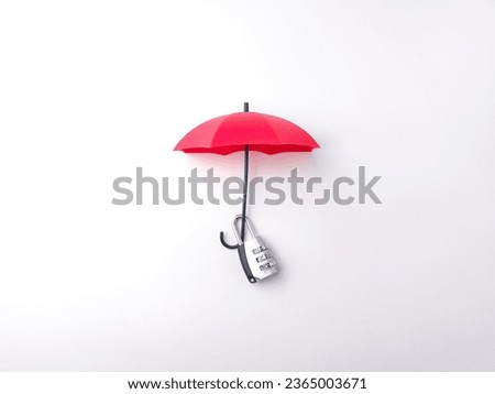 Silver padlock hanging on a red umbrella on a white background