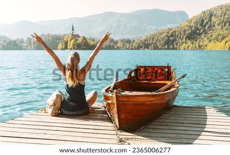 Happy female tourist with open arms enjoying view of lake bled in Slovenia Royalty-Free Stock Photo #2365006277