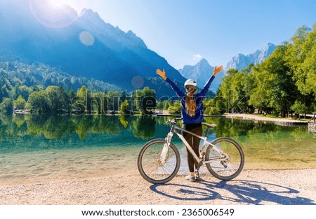 woman with arms raised enjoying beautiful emerald lake in Slovenia- travel, vacation,tourism in Europe