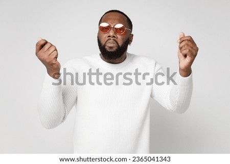 Displeased upset young man of African American ethnicity wear basic sweater eyeglasses standing spreading hands clenching fists looking camera isolated on white color wall background studio portrait Royalty-Free Stock Photo #2365041343