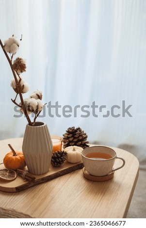 Autumn decor. Hot drink. Mug of tea, book, pumpkin, candle on a wooden coffee table. Autumn. Fall.