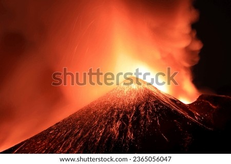 Etna volcano in Sicily-Italy in a panoramic view on great nocturne eruption under starry sky and large quantities of gas and ash illuminated by lava flow; Taken 13 August 2023.