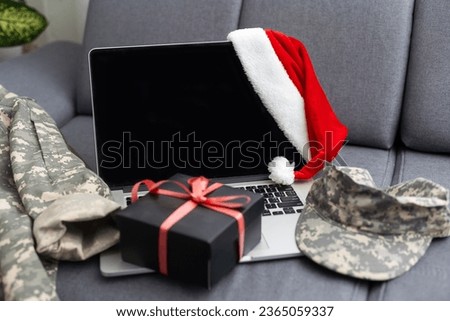 military uniform and a Santa hat with a laptop. The concept of Christmas and New Year.