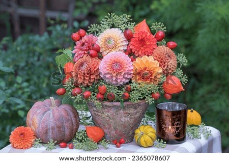 autumn arrangement with bouquet of orange and yellow dahlias, rose hips and ivy flowers and pumpkins Royalty-Free Stock Photo #2365078607