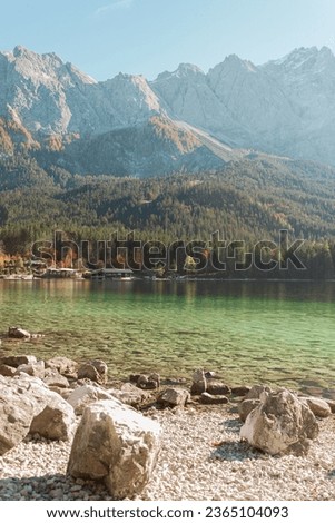 Calm relaxing landscape with Alpine mountains and autumn forest in Bavaria, Germany. Sunny day on the lake shore