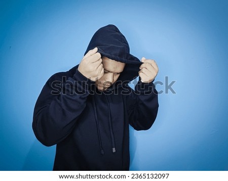 A man in a black jacket poses with his hood off