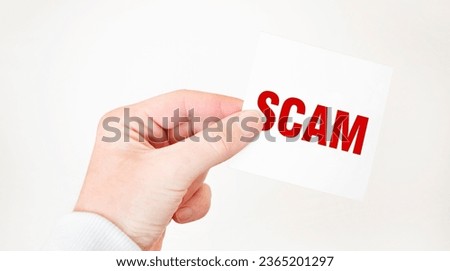 Businessman holding a card with text SCAM, business concept