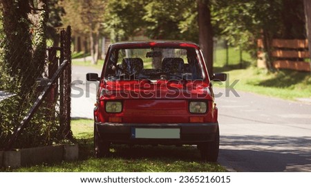 Little Fiat portrait for commercial use. Small red car on the road. Retro vehicle outdoors. Royalty-Free Stock Photo #2365216015