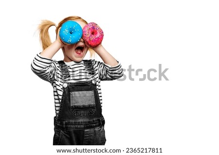 Happy cute girl is having fun played with donuts on white background. Bright photo of a child. Colored donuts