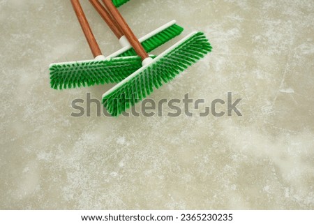 Green Ice Cleaning Brushes. Brushes on ice. Cleaning tool. Winter cleaning equipment.