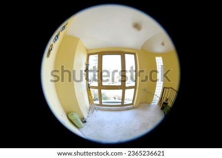 Empty corridor, floor and stairways are visible through the door peephole         Royalty-Free Stock Photo #2365236621