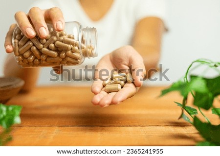 Capsules of plant origin held in hand, nature, laboratory, science of dietary supplements Royalty-Free Stock Photo #2365241955