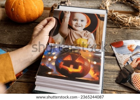 Person looking through photo album with Halloween printed photos.