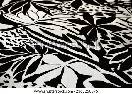 Black and white design of forest leaves on fabric.
