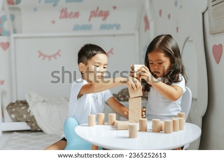 children boy and girl play with wooden toys at home in children's bedroom Royalty-Free Stock Photo #2365252613