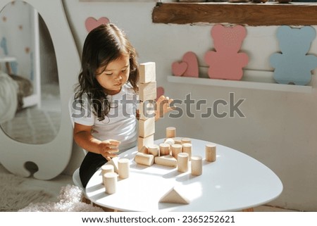 children boy and girl play with wooden toys at home in children's bedroom Royalty-Free Stock Photo #2365252621