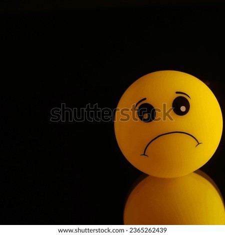 3D sad emoji with reflection isolated in black background 
