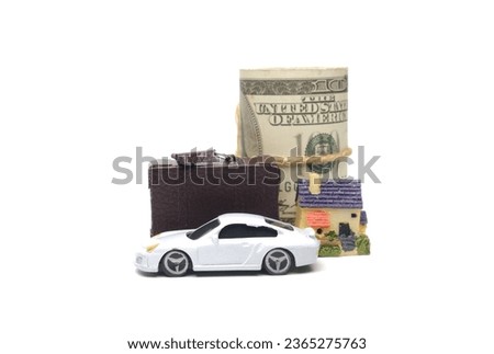 A picture of diorama car, briefcase, house miniature and roll of fake money. Asset management concept
