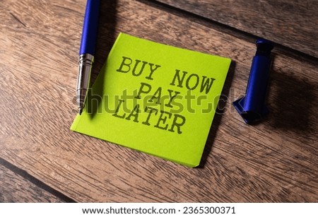 blank note pad with text buy now pay later on green wooden background. Royalty-Free Stock Photo #2365300371