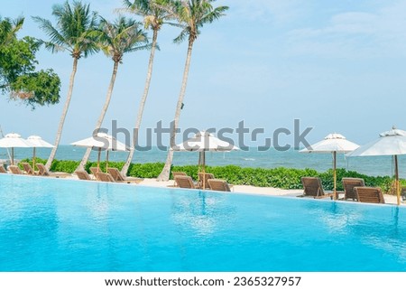 umbrella with bed pool around swimming pool with ocean sea background - holiday and vacation concept
