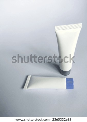Place two tubes of cream on a white background.