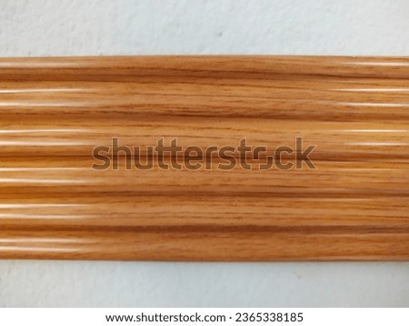 Background of brown wooden strips on white cement.