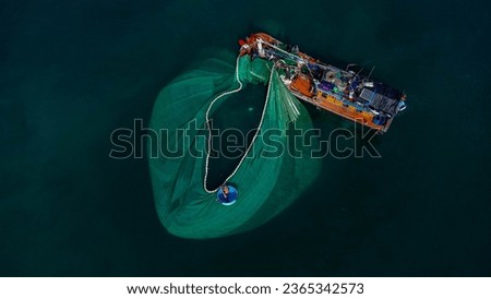 Close-up of offshore fishing boat casting fishing net recorded by flycam