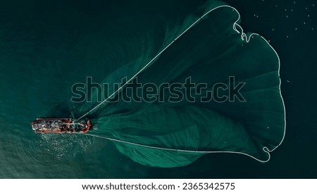 Close-up of offshore fishing boat casting fishing net recorded by flycam Royalty-Free Stock Photo #2365342575