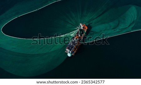 Close-up of offshore fishing boat casting fishing net recorded by flycam