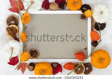 Mock up flat lay template white portrait frame with fall branches and pumpkin decor on wooden background. Autumn concept with copy space for text