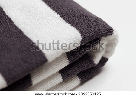 Close up of a towel folded into several with black and white color, soft fluffy textile