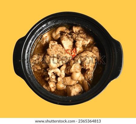 Chicken soup in black bowl isolated with clipping path, no shadow in yellow background