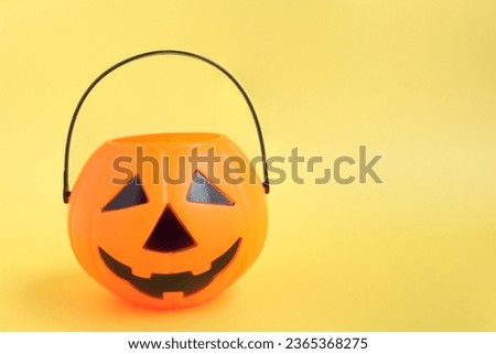 Jack'O pumpkin basket. Halloween cute plastic toy pumpkin head basket on yellow background.Trick or Treat
