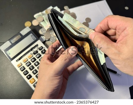 Cash in wallet and investing  Royalty-Free Stock Photo #2365376427
