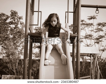 Little cute girl swinging in park.Different pose with filter  effect on camera raw photo.Light and dark preset editing.Kid girl sitting on bench.
