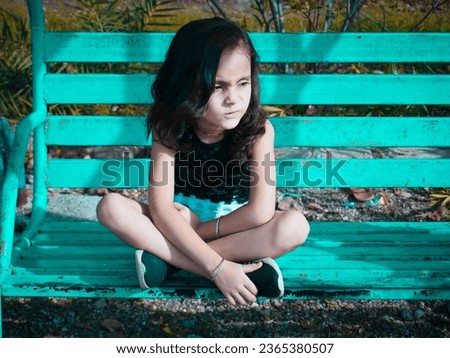 Little cute girl swinging in park.Different pose with filter  effect on camera raw photo.Light and dark preset editing.Kid girl sitting on bench.