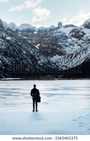 man contemplating snowy mountain in solitude