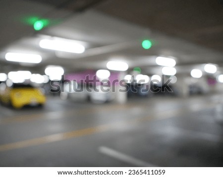 Blur focus of Underground parking. Cars parked in a garage with no people. Many cars in parking garage interior. Underground parking with cars